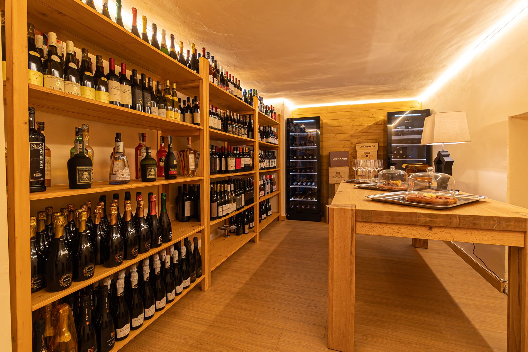 Gli scaffali della cantina con le bottiglie di vino