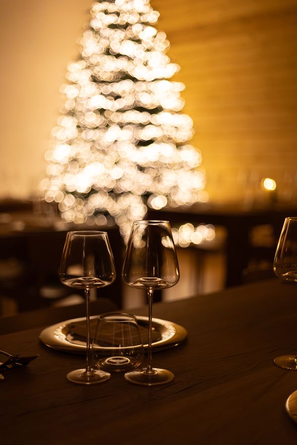 Calici sul tavolo davanti all'albero illuminato