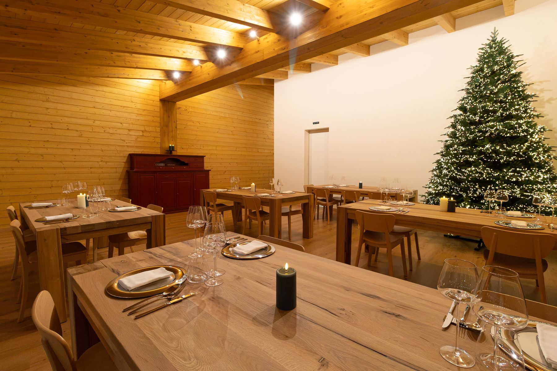 La sala del ristorante con i tavoli apparecchiati e l'albero